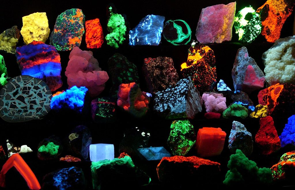 Collection of various fluorescent minerals under ultraviolet UV-A, UV-B and UV-C light. Chemicals in the rocks absorb the ultraviolet light and emit visible light of various colors, a process called fluorescence.