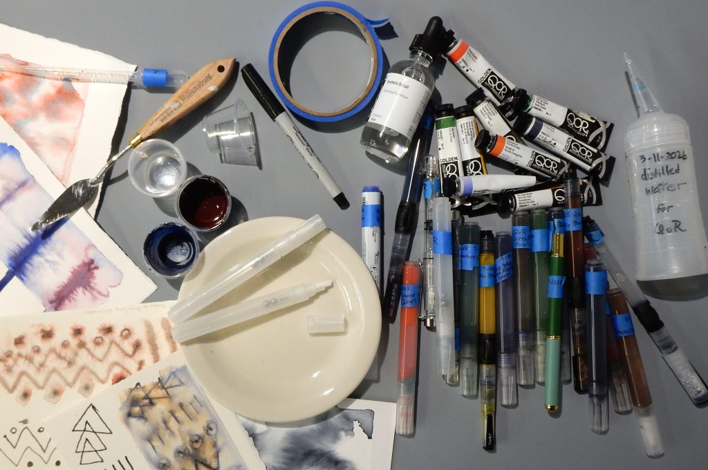 image of supplies for testing QoR Watercolor in paint markers and brush pens